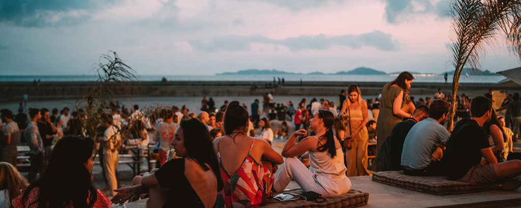 personnes assises sur la plage à la cabane des amis marseille